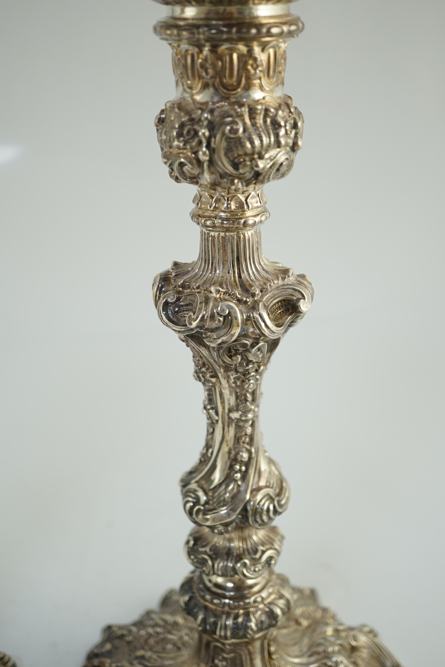 An ornate pair of Edwardian silver candlesticks, by Walker & Hall